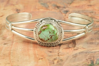 Genuine Royston Turquoise set in Sterling Silver Bracelet. The Royston Turquoise Mine was originally known as the Royal Blue Mine. It produces Turquoise that has a mixture of blues and greens in the same formation. The Royston Turquoise Mine is located in Nye County, Nevada. Created by Navajo Artist John Nelson. Signed by the artist.